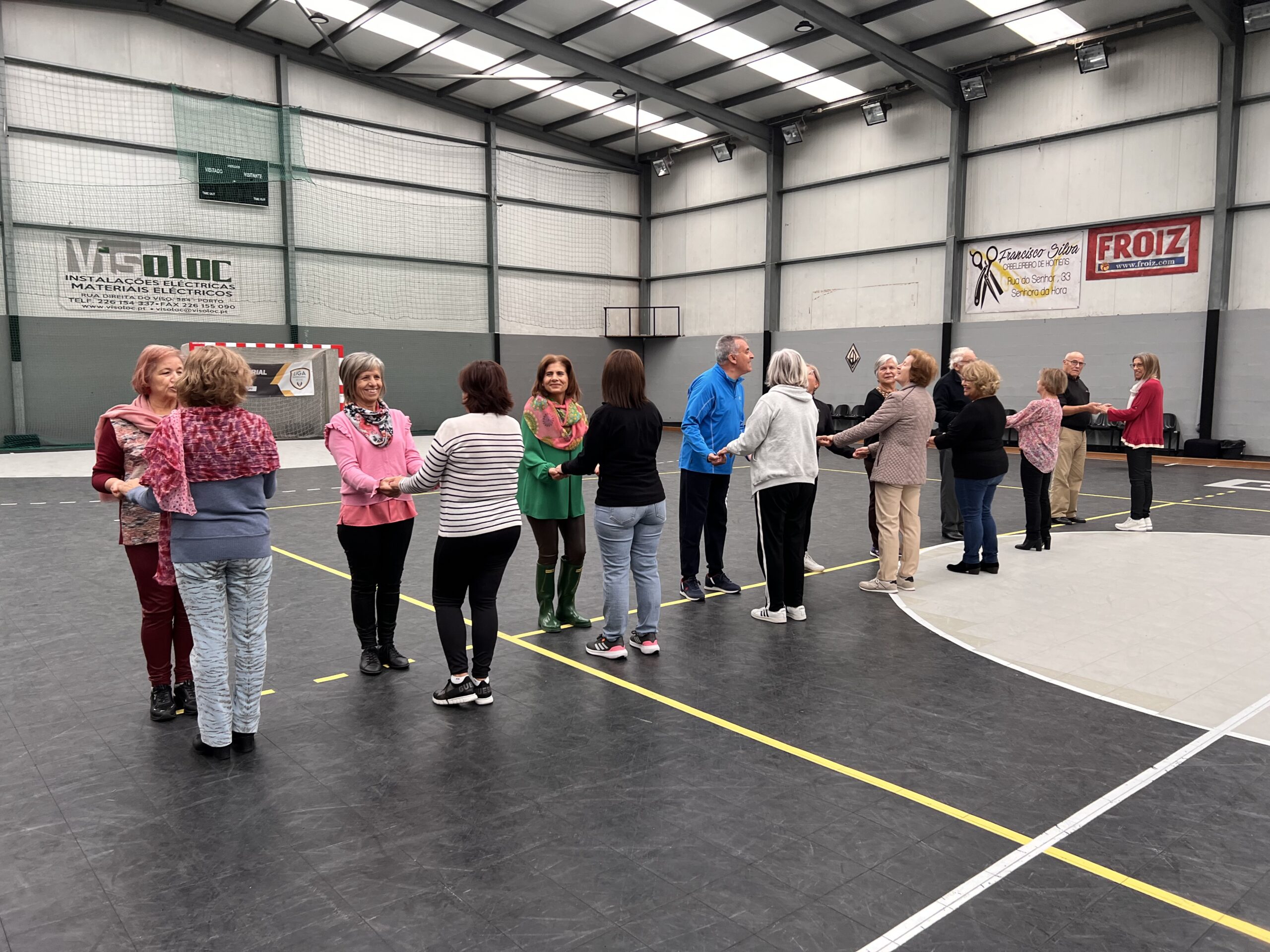 Grupo de idosos a praticar exercícios numa quadra