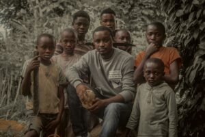 um homens e outras crianças africanas olhando para a camera