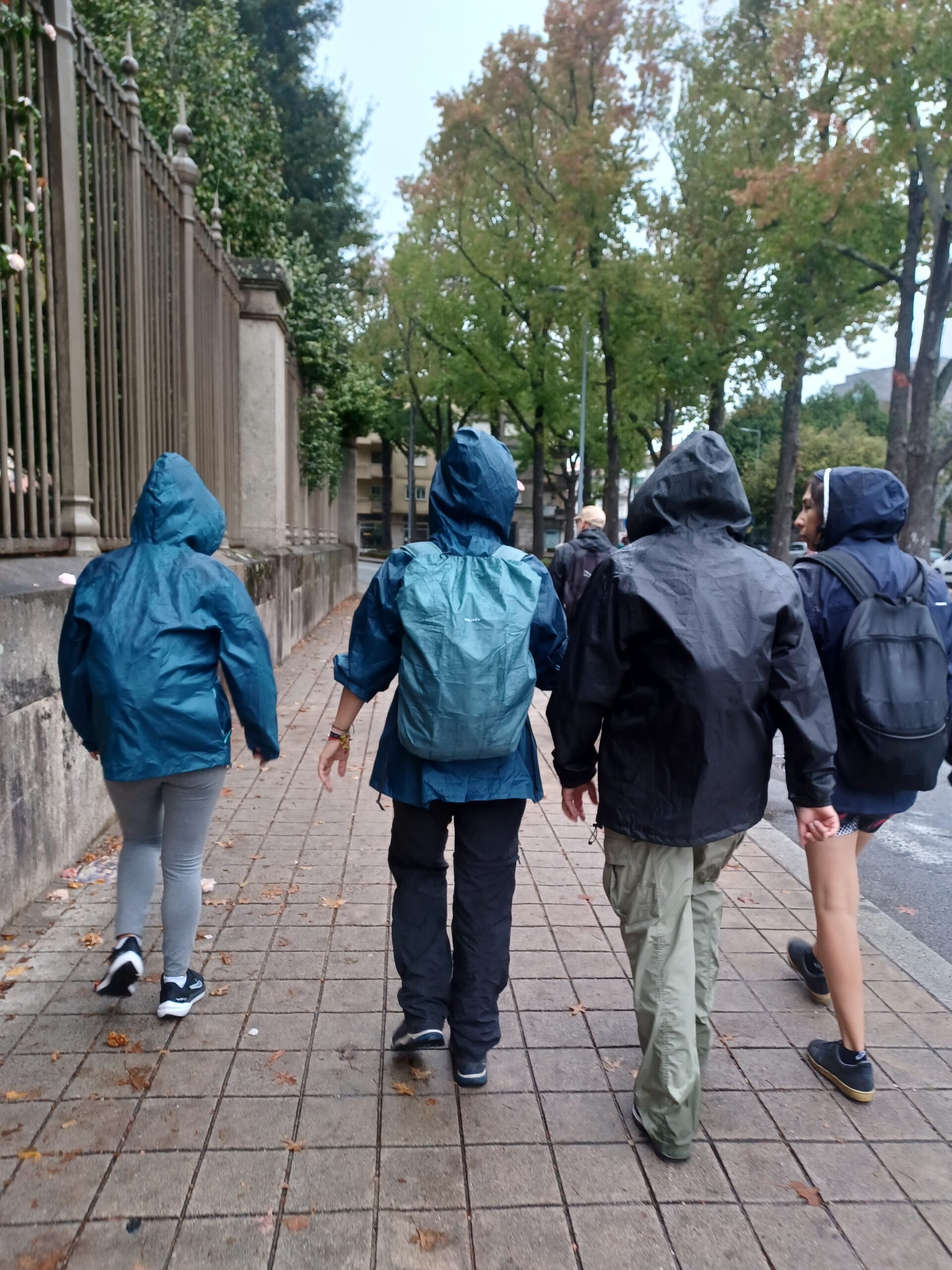 Pessoas caminhando vestindo casacos e capuz em um dia chuvoso. caminho de santiago porto